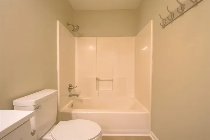 A compact bathroom offers a combined shower and bathtub for convenience.