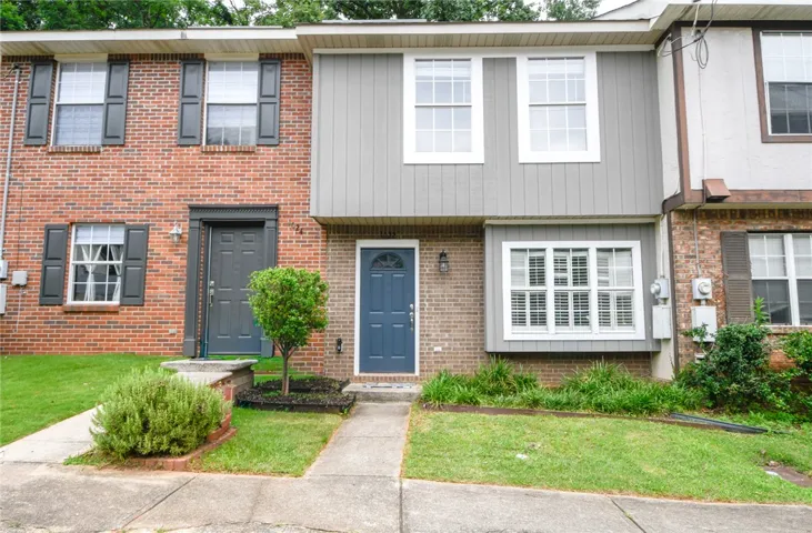 A classic brick and siding townhouse with a welcoming blue entry door offers pleasant curb appeal.