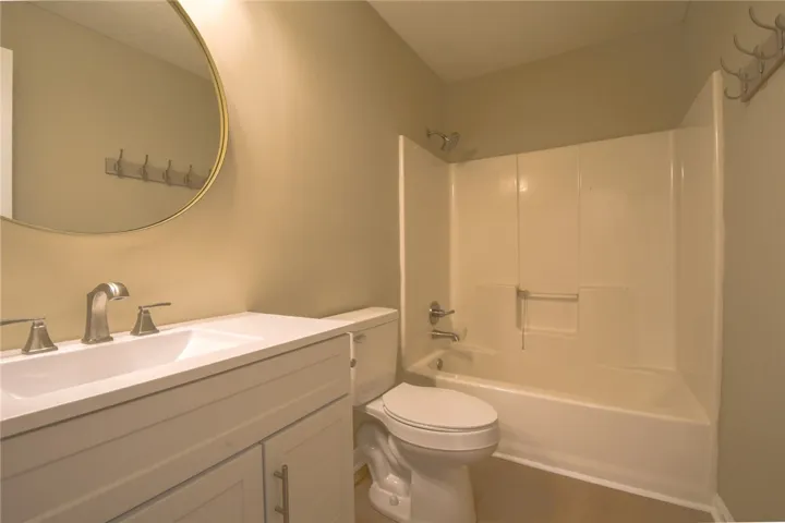 A well-appointed bathroom features a crisp white vanity and a practical shower-tub combination.