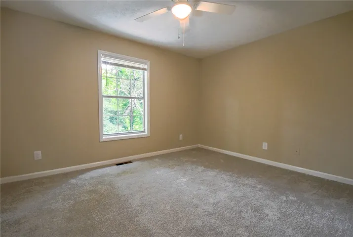 A well-proportioned bedroom with carpeting offers a tranquil retreat.