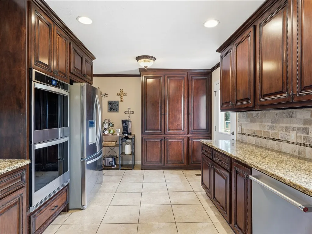 Rich wood cabinetry and polished granite counters define this inviting culinary space.
