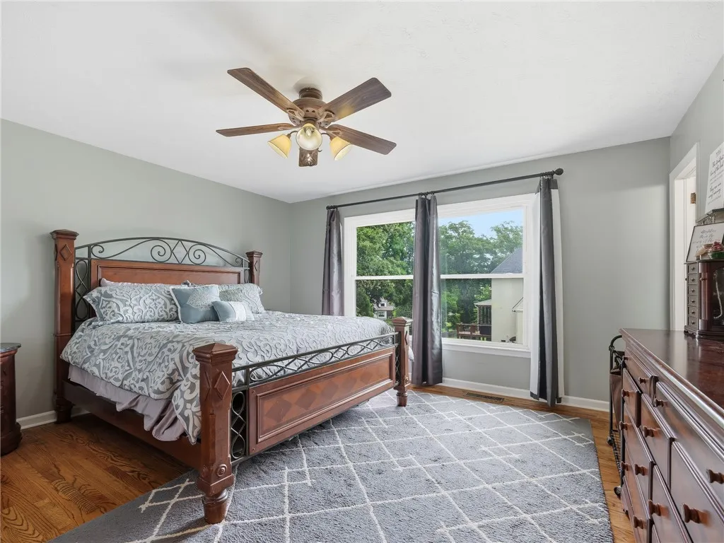 Hardwood floors and generous windows create a tranquil bedroom retreat.