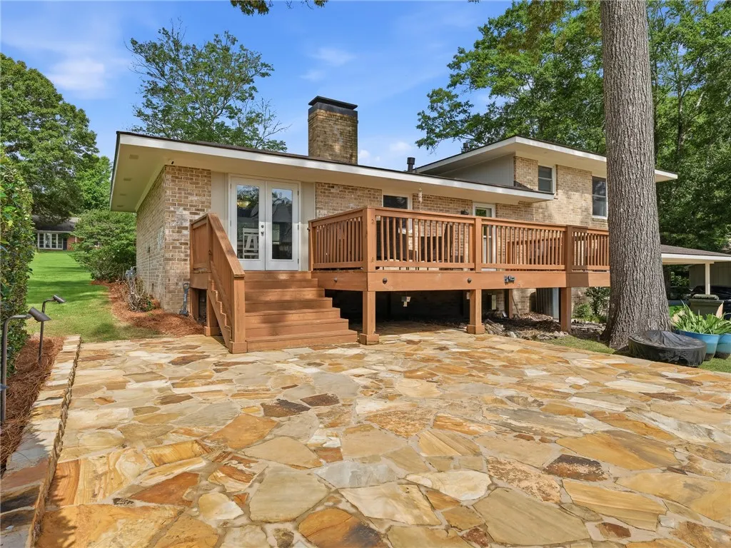An inviting flagstone patio and a spacious elevated deck provide ample outdoor living space.