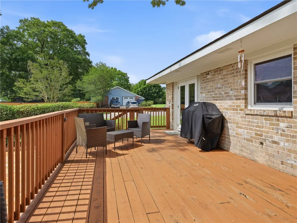 A spacious wooden deck provides ample outdoor living space, perfect for entertaining.