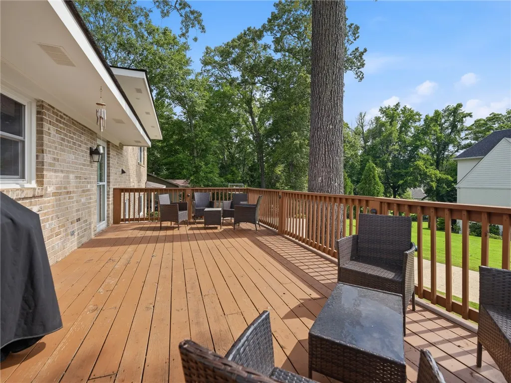 A spacious wooden deck provides ample outdoor living space, perfect for entertaining.