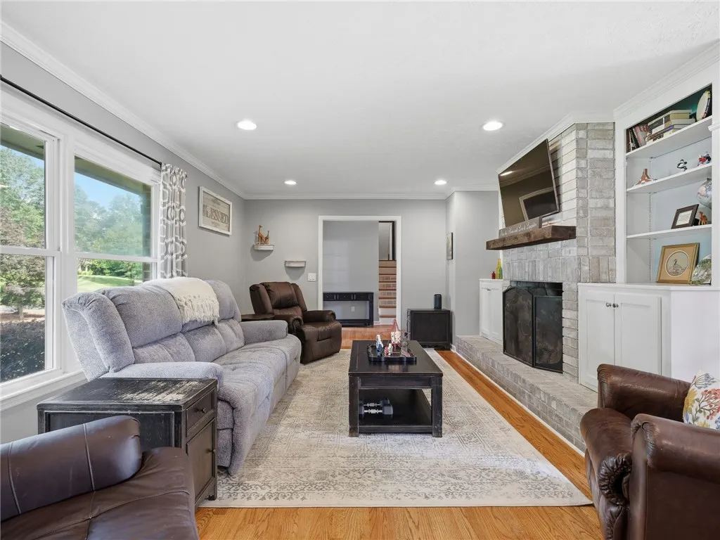 A welcoming living area boasts a cozy brick fireplace and built-in shelving, perfect for relaxation.