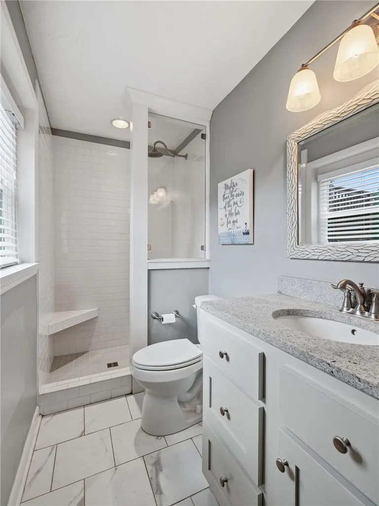 A well-appointed bathroom features a spacious walk-in shower and a sleek vanity with ample storage.