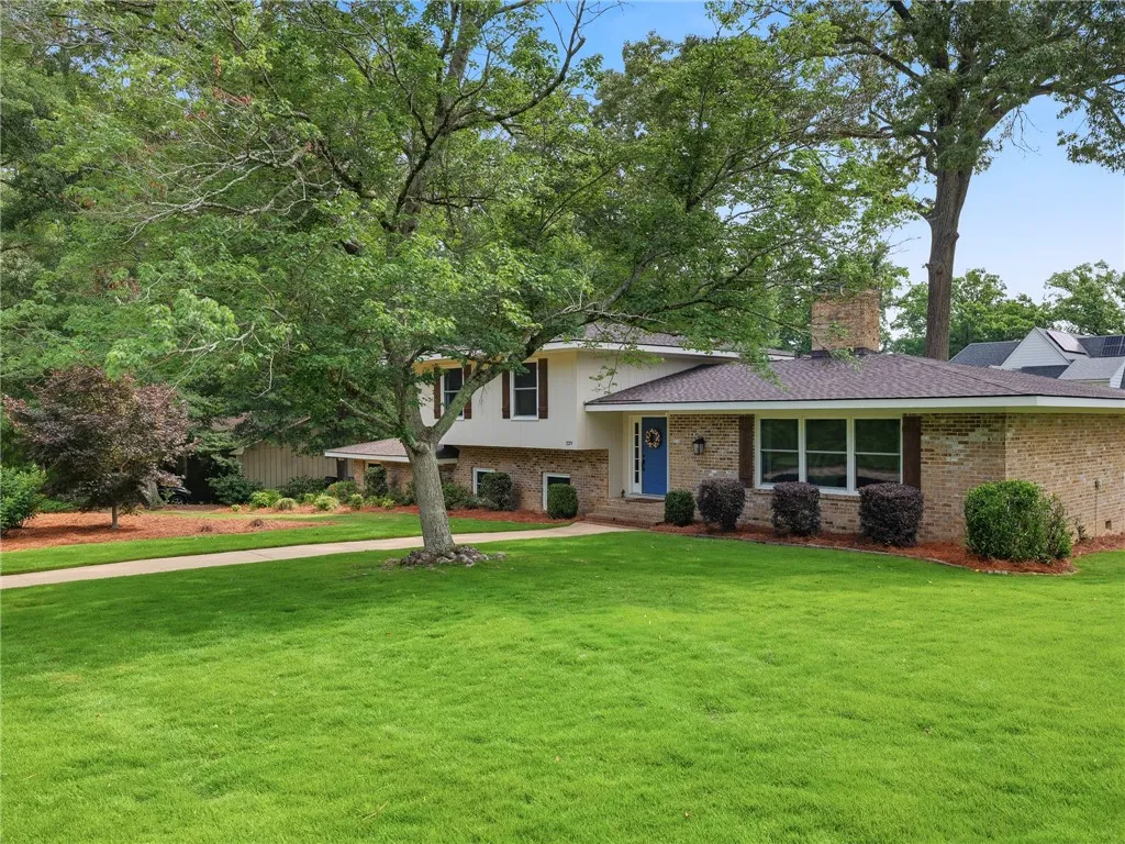 A well-maintained lawn welcomes visitors to this classic brick and siding residence.
