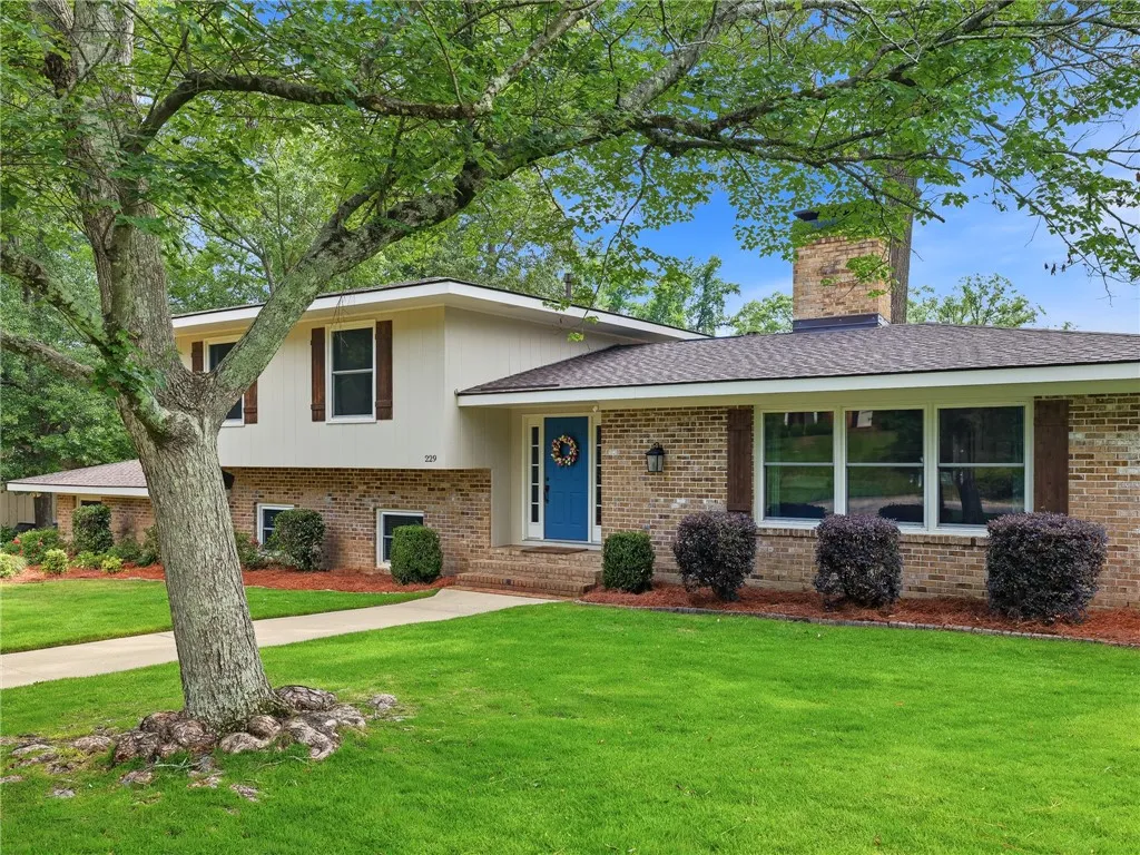 A classic brick exterior with a welcoming blue entry door and well-kept landscaping.