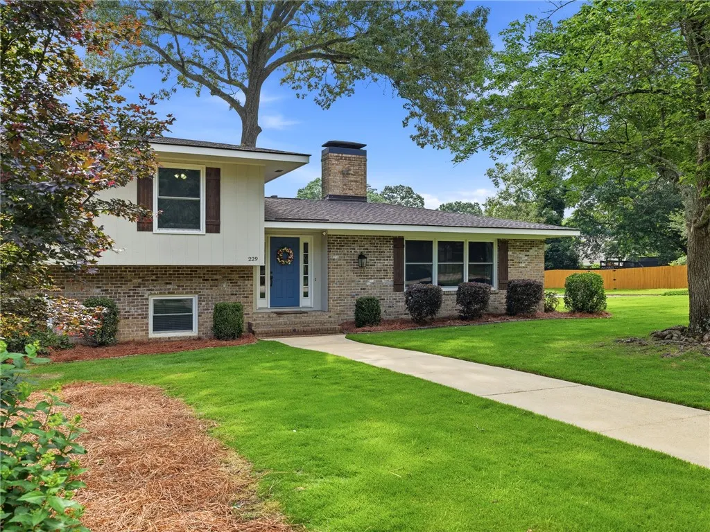 A well-maintained lawn and classic brick facade create inviting curb appeal for this charming residence.