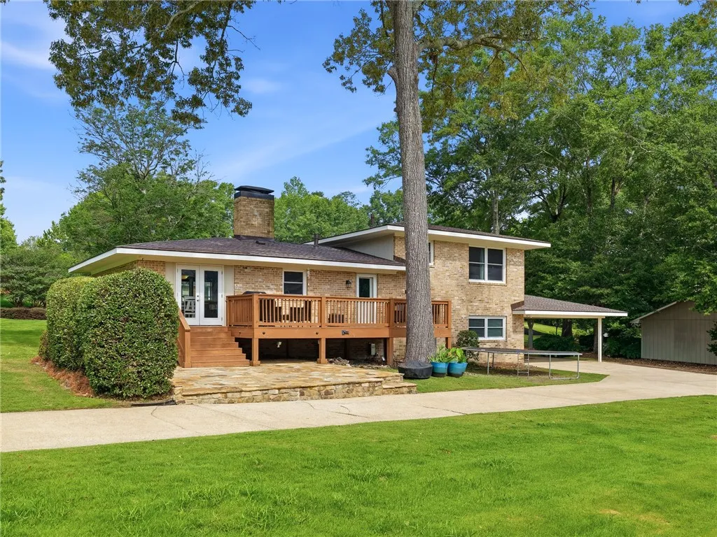 A classic brick exterior blends seamlessly with the verdant landscaping, offering a serene outdoor retreat.