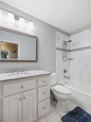 Granite counters and tiled shower create a pristine and inviting bathroom environment.