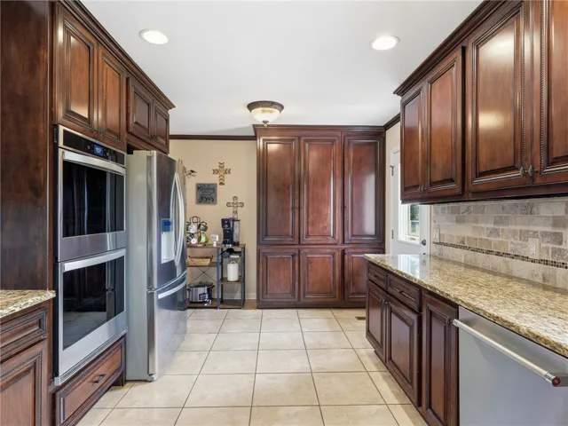 Rich wood cabinetry and polished granite counters define this inviting culinary space.