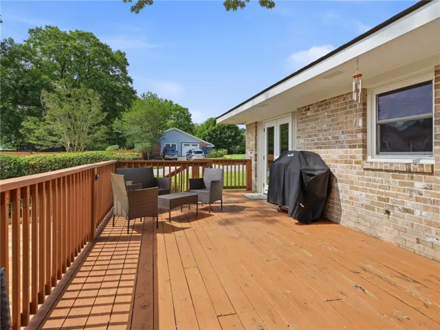 A spacious wooden deck provides ample outdoor living space, perfect for entertaining.