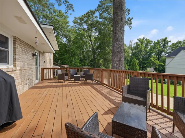A spacious wooden deck provides ample outdoor living space, perfect for entertaining.