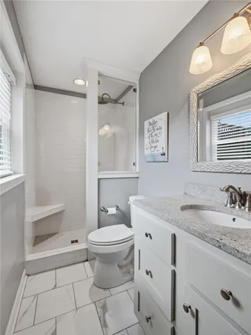 A well-appointed bathroom features a spacious walk-in shower and a sleek vanity with ample storage.