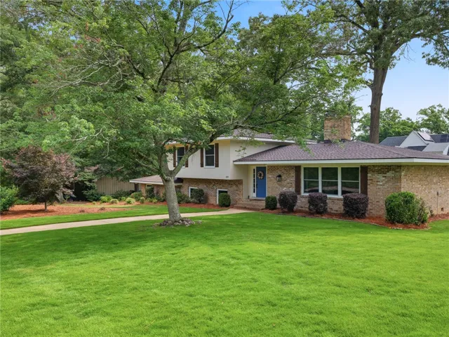 A well-maintained lawn welcomes visitors to this classic brick and siding residence.