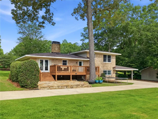 A classic brick exterior blends seamlessly with the verdant landscaping, offering a serene outdoor retreat.