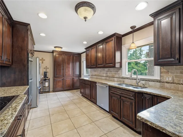 Warm wood cabinetry and durable granite counters outfit this spacious, well-appointed cooking area.