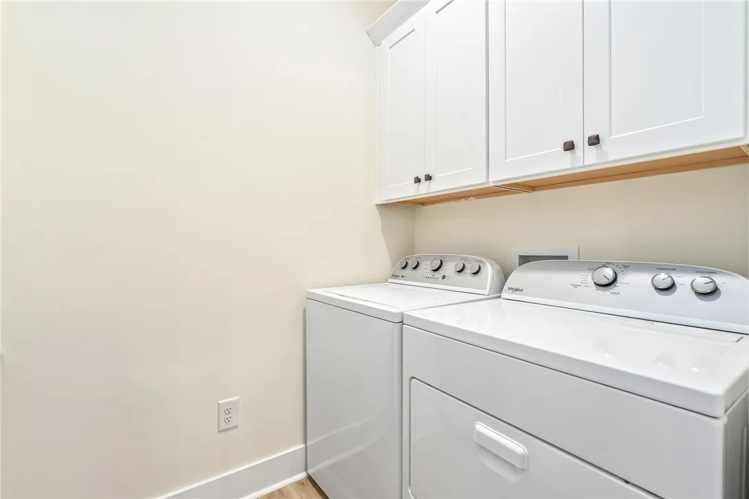 Functional laundry space featuring modern appliances and practical cabinetry.