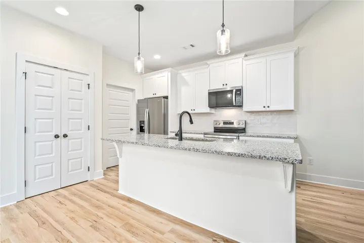 A well-appointed kitchen showcasing elegant pendant lighting and a spacious island for culinary endeavors.