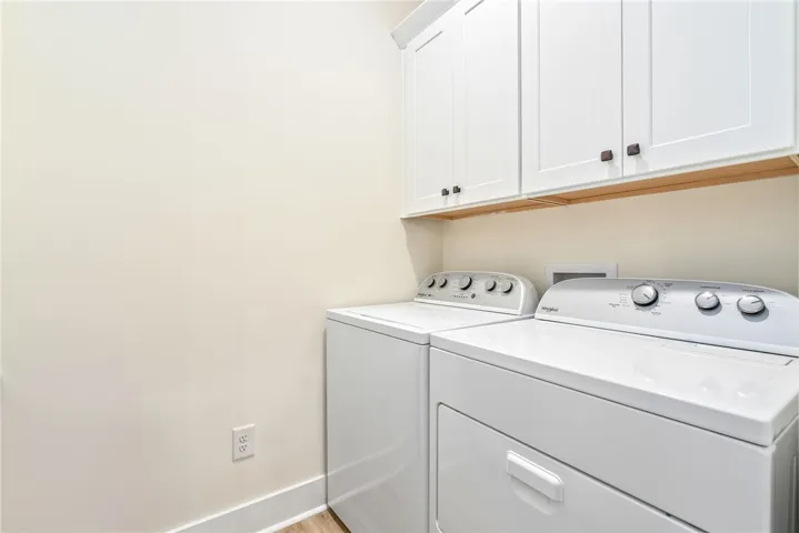 Functional laundry space featuring modern appliances and practical cabinetry.