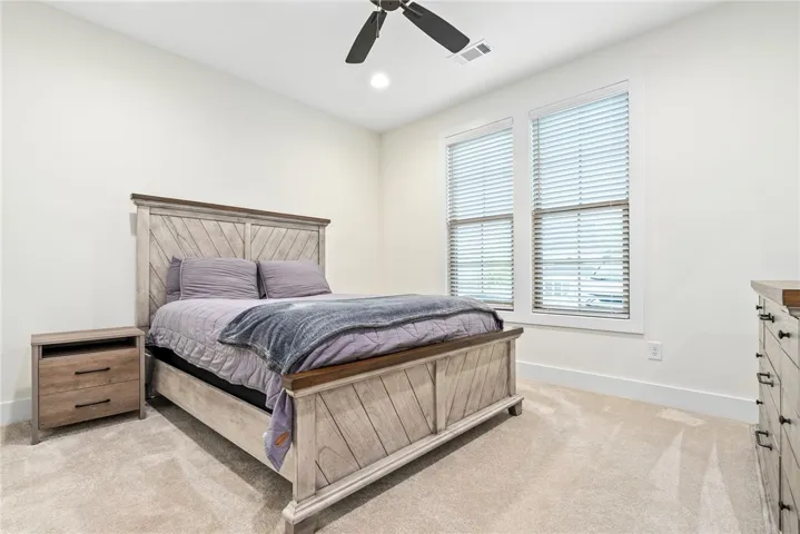 A well-lit bedroom with comfortable carpeting, ready for tranquil rest and peaceful slumber.