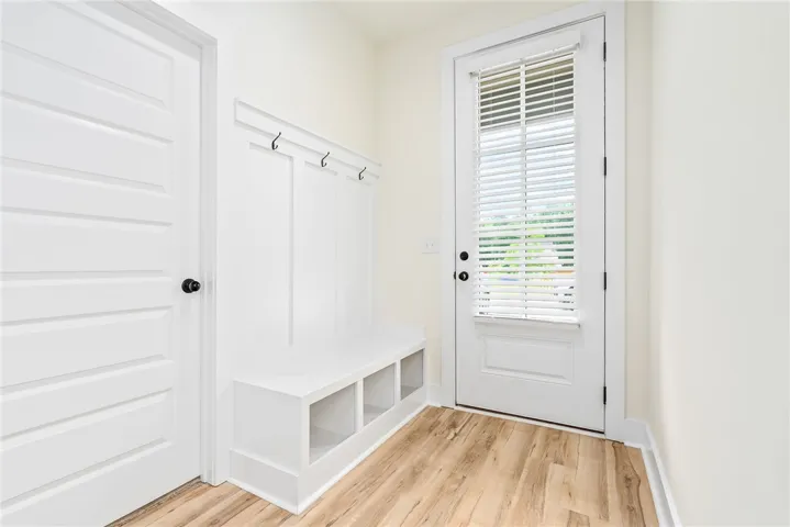 A built-in bench with storage and coat hooks provides a functional and organized entry.
