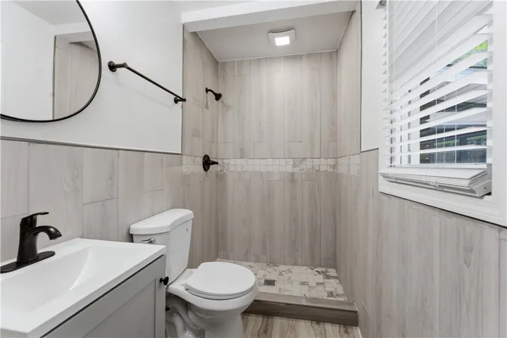 Master bathroom features a standing shower with attractive tile work and a window for natural light.