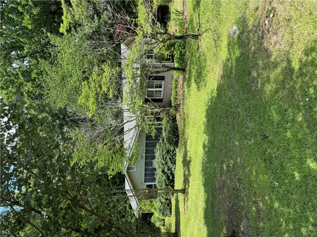 A classic facade nestled amidst mature trees, offering a private oasis.