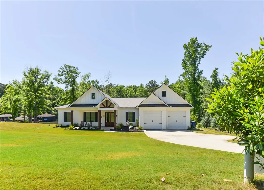 A spacious front yard introduces this modern farmhouse with a prominent two-car garage and inviting porch.