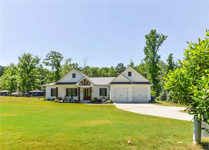 A spacious front yard introduces this modern farmhouse with a prominent two-car garage and inviting porch.