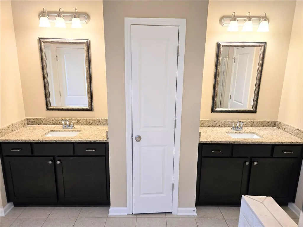 Indulge in a primary bathroom featuring dual vanities with granite counters.