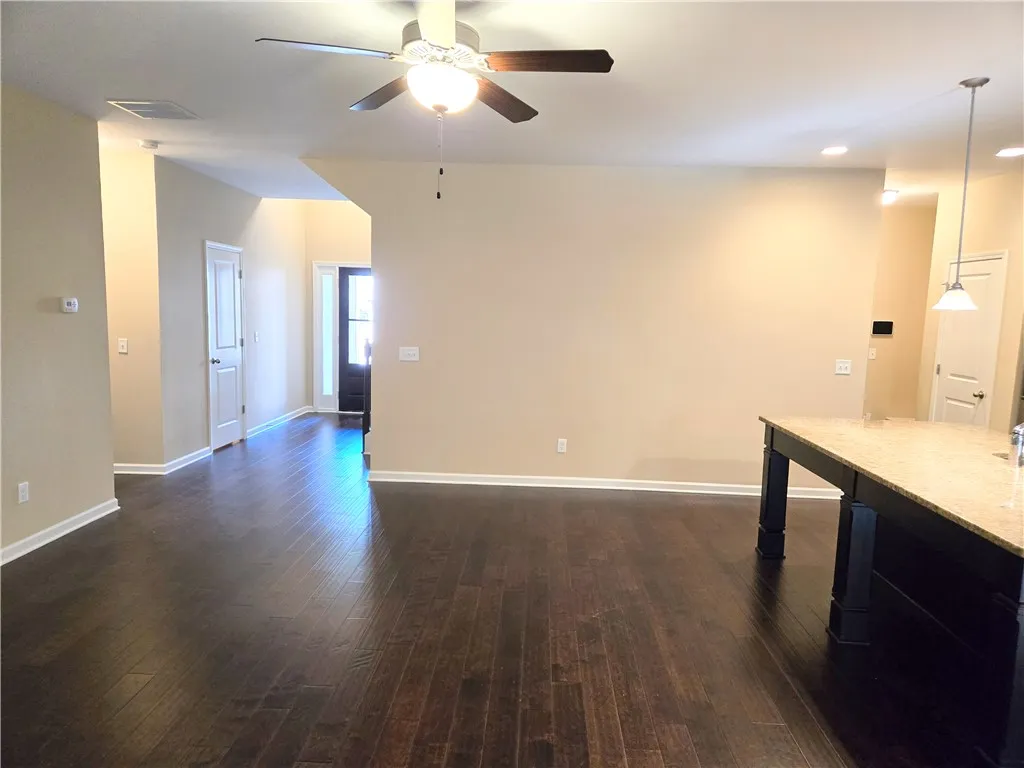 Rich hardwood floors flow through this open-concept space, complemented by a versatile kitchen island.