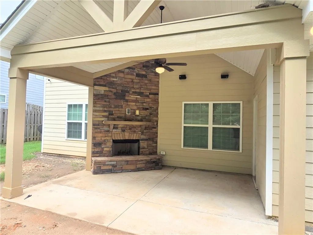 An inviting covered patio features a stone fireplace for year-round enjoyment.