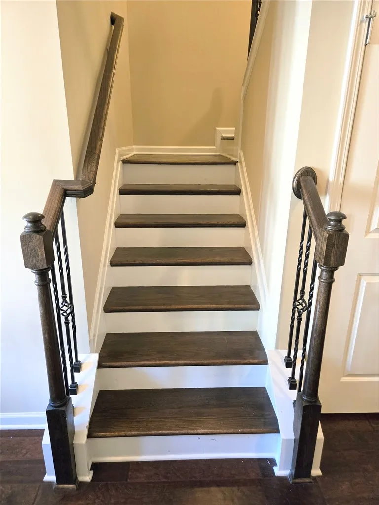 Hardwood stairs with wrought iron balusters lead to the upper level.