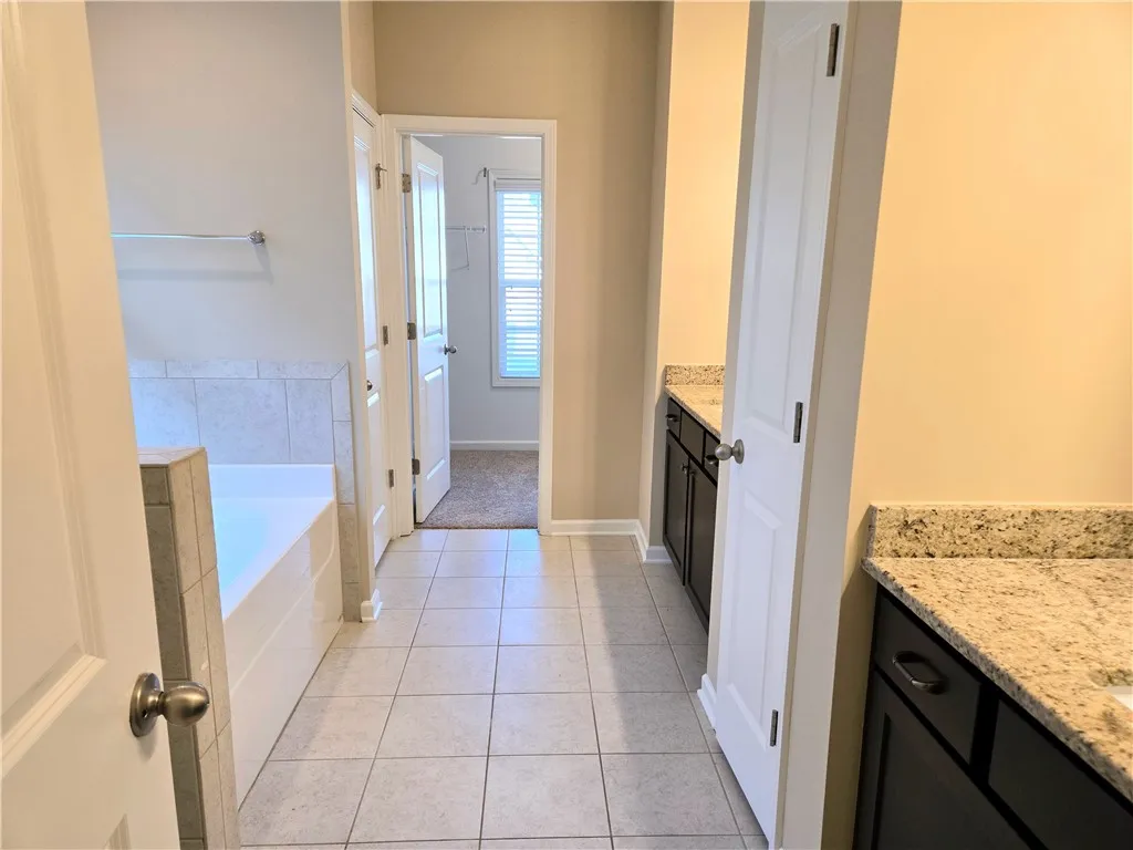 Granite counters and tiled flooring complement this well-appointed bathroom space.