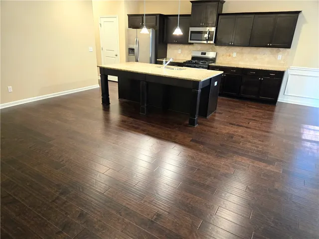 A gourmet kitchen island with granite countertops anchors this open-concept living space.