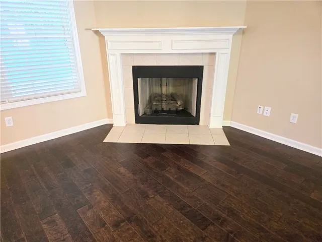 Warm wood flooring extends to a prominent fireplace, creating an inviting living space.