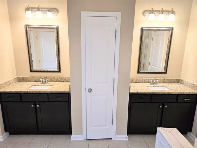 Indulge in a primary bathroom featuring dual vanities with granite counters.