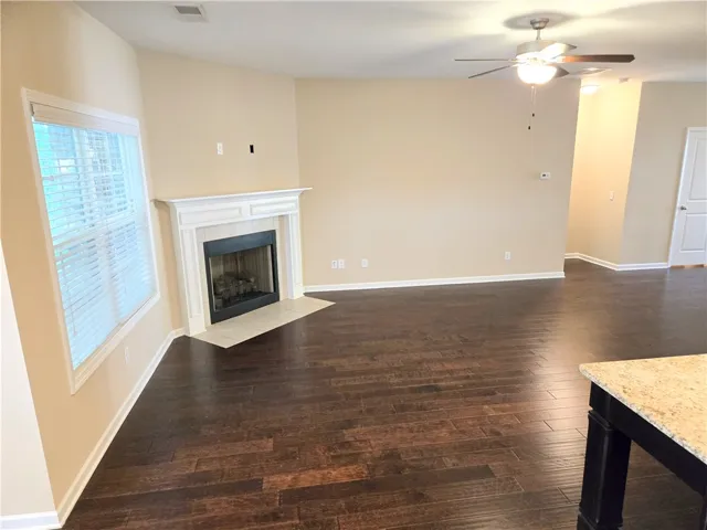 A well-proportioned living area features rich hardwood flooring and a classic fireplace focal point.