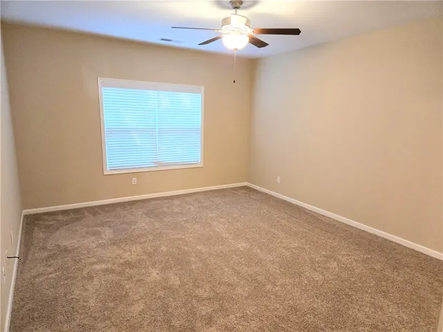 A quiet bedroom with plush carpeting and natural light for tranquil evenings.