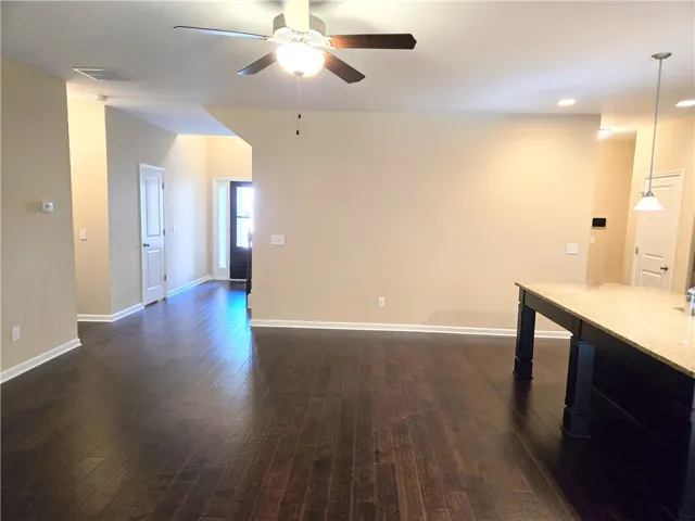 Rich hardwood floors flow through this open-concept space, complemented by a versatile kitchen island.