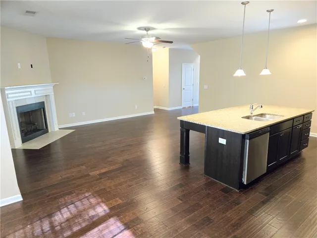 Rich hardwood floors unite an open-concept living area and a spacious kitchen island, perfect for entertaining.