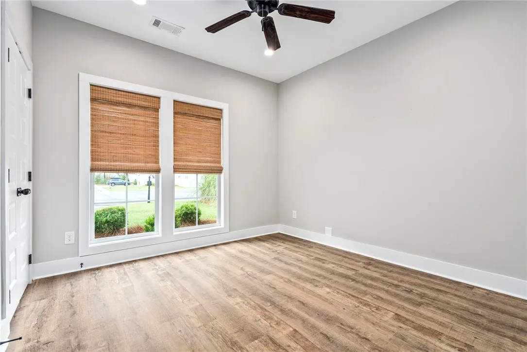 A well-lit room offers ample natural light and durable wood-style flooring.
