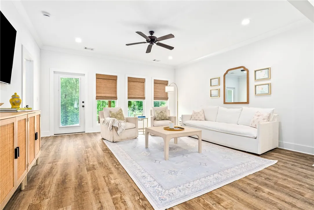 Rich wood-look flooring and ample natural light define this inviting living space.