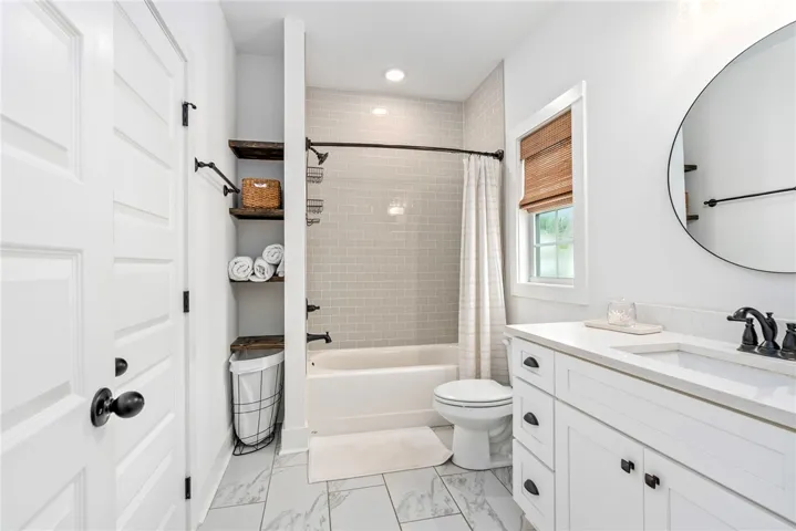 White cabinetry, a full bath, and an integrated vanity sink create a serene and practical bathroom space.