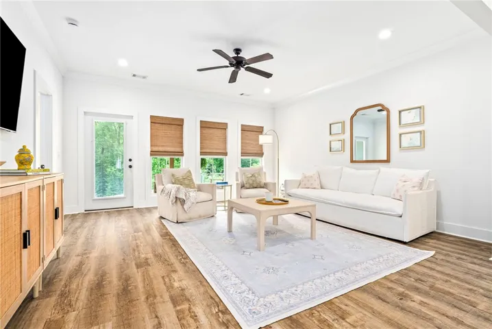 Rich wood-look flooring and ample natural light define this inviting living space.