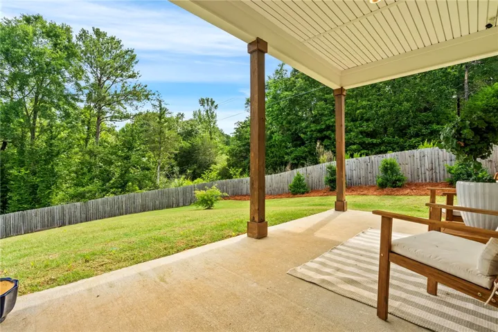 A spacious covered patio invites relaxation with a verdant, fenced backyard.