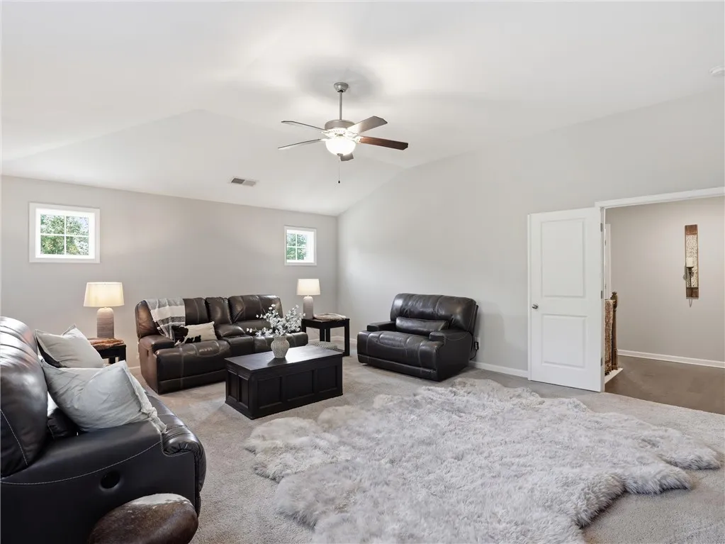 The generously sized living area offers vaulted ceilings and comfortable carpeted flooring, perfect for relaxation.